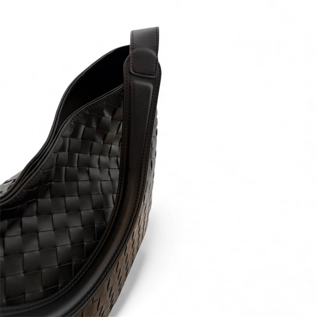 Close-up of a black woven leather saddle pad on a white background