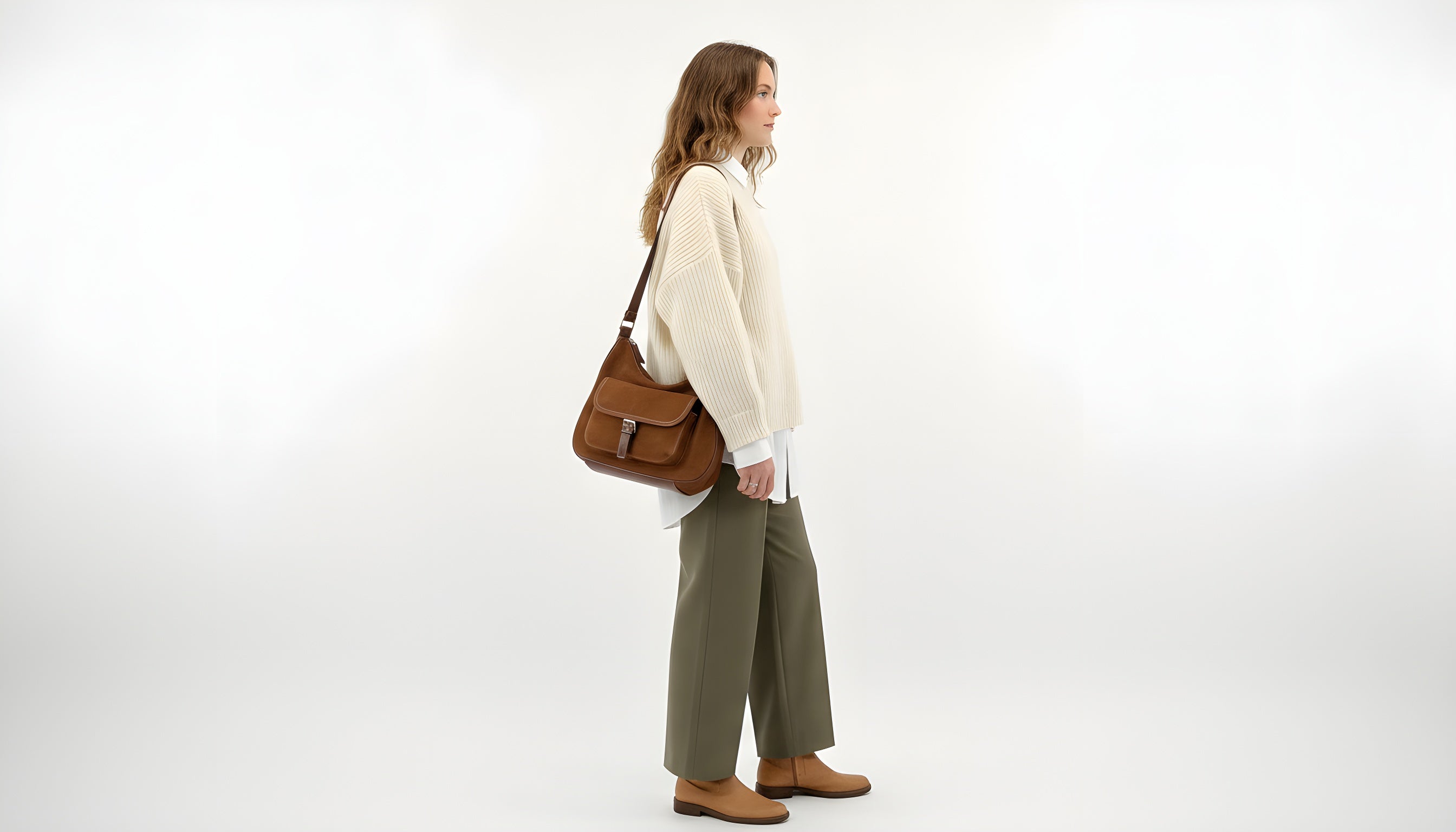 Woman holding a brown leather bag on a white background