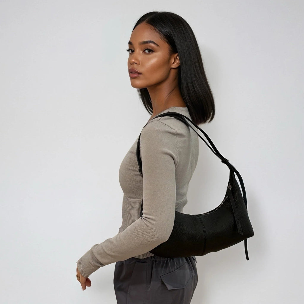 Woman carrying a black handbag against a white background