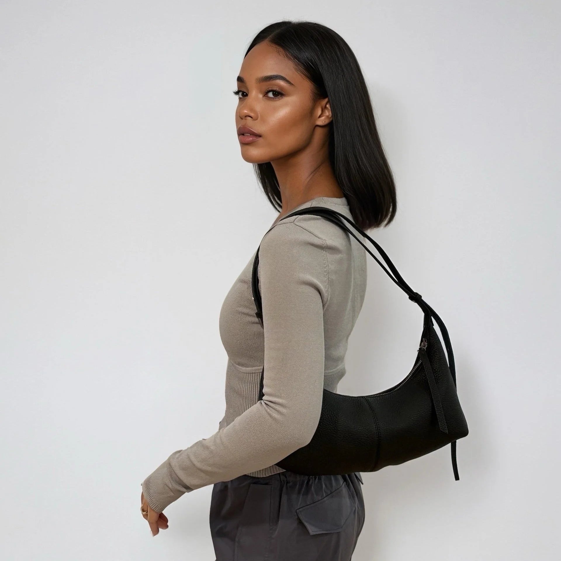 Woman carrying a black handbag against a white background