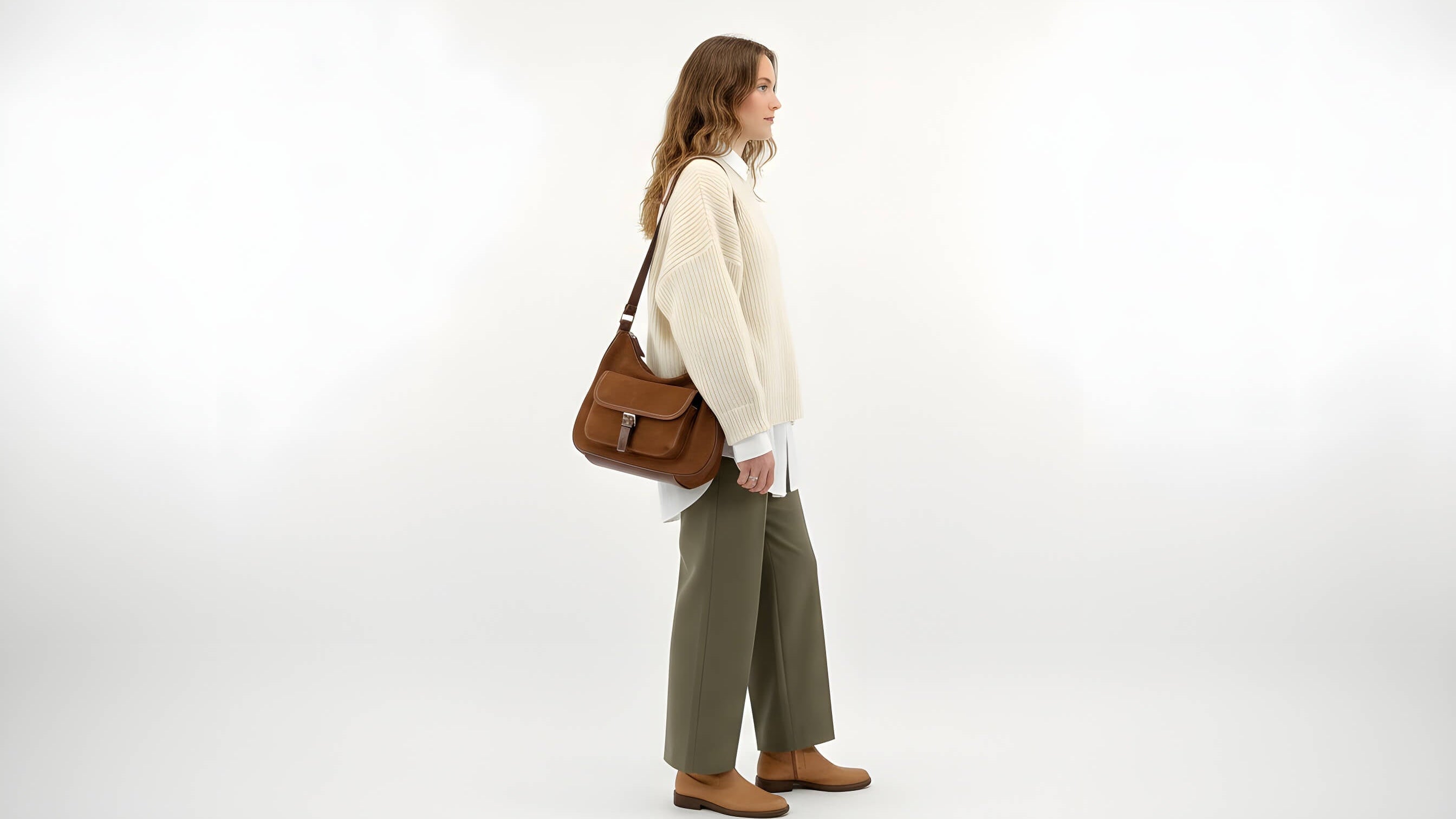 Woman holding a brown leather bag on a white background